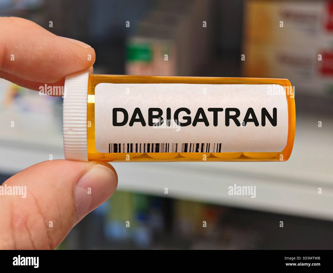 Orange Plastikbox von DABIGATRAN Tabletten auf einem Krankenhaus Apothekentisch verwendet, um Schlaganfall und Blutgerinnsel ein Antikoagulans zu verhindern. Apothekenlager Stockfoto