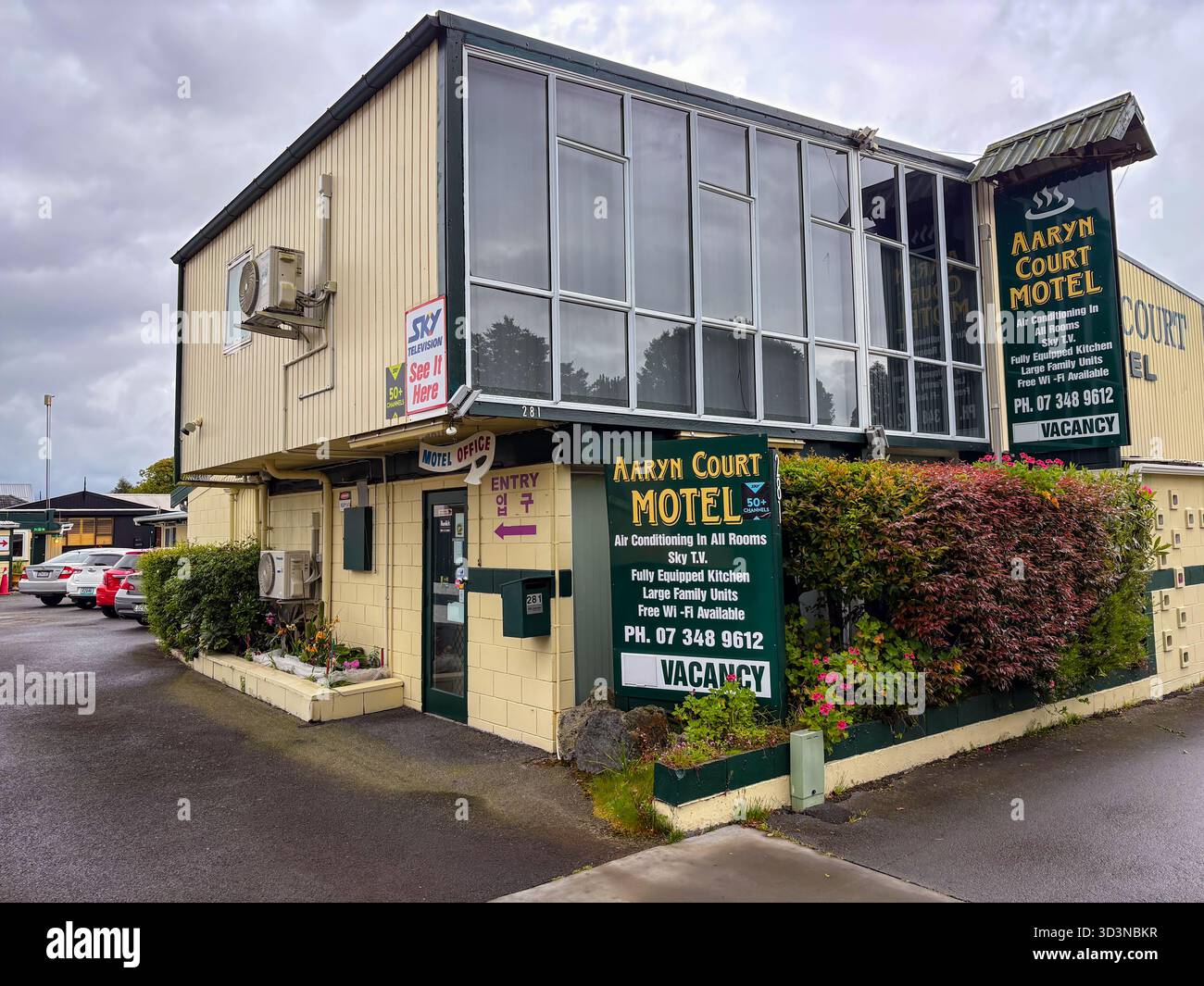 Aaryn Court Motel Gebäude von außen an einem bewölkten Tag in Rotorua, Neuseeland. Mit sichtbaren Schildern, die Motel-Annehmlichkeiten wie Klimaanlage, Stockfoto