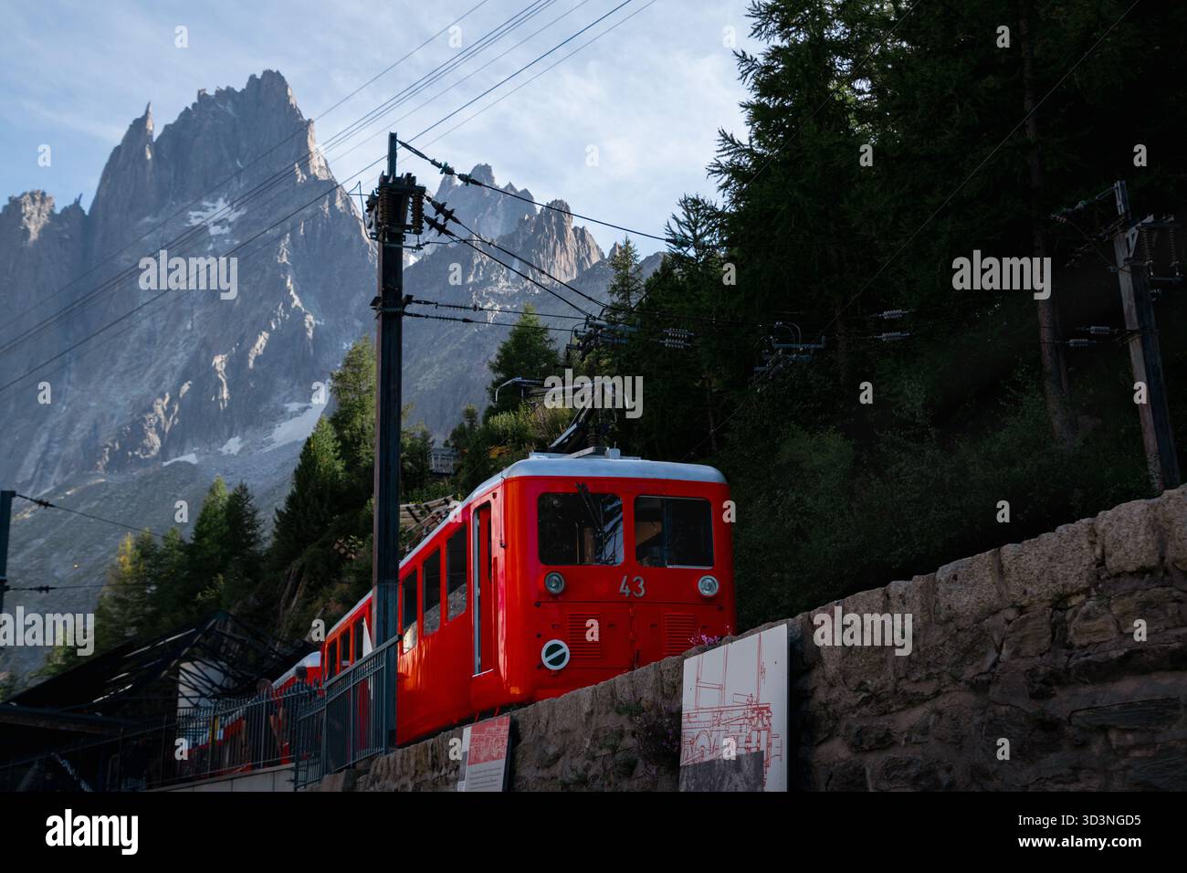 Historische Rote Zahnradbahn an der Bergstation in Chamonix unter hoch aufragenden Felsenspitzen Stockfoto