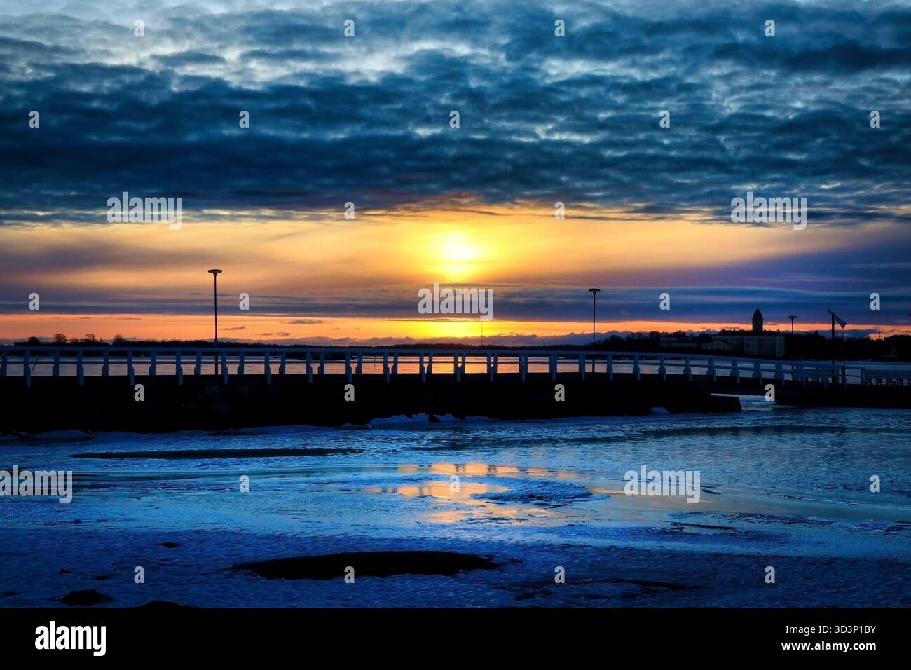 Dramatischer Sonnenaufgang über Meer und Pier mit teilweise bewölktem Himmel im Winter. Natürliches Foto. Stockfoto