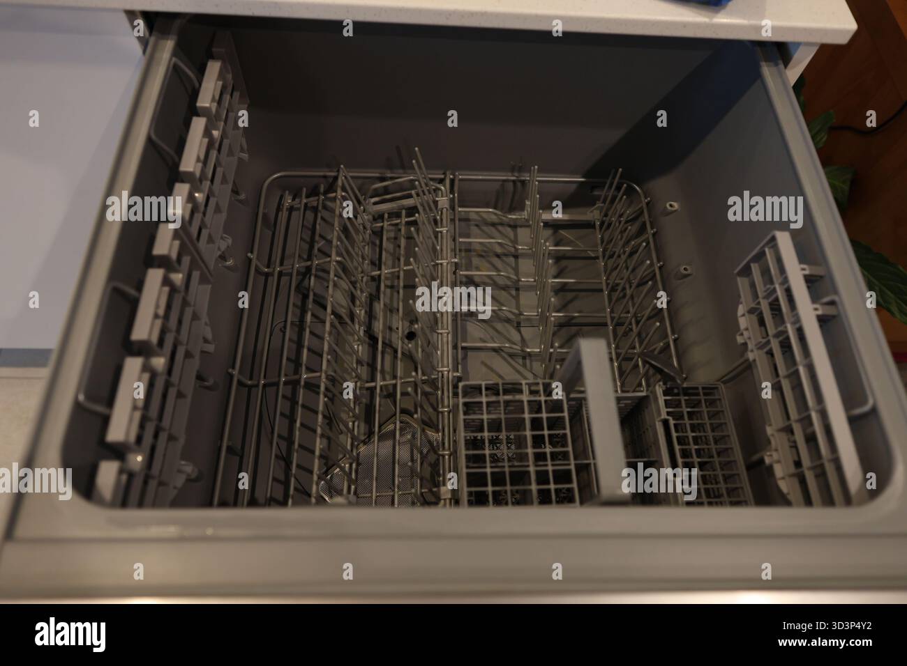 Öffnen und leeren Sie die Schublade des Geschirrspülers Stockfoto