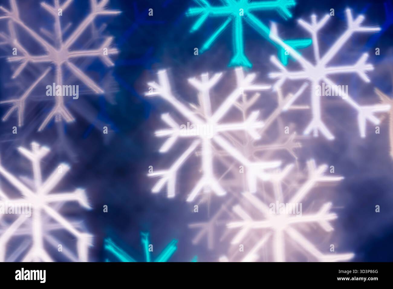 Weißes blaues türkisfarbenes Schneeflocken-Bokeh auf schwarzem Hintergrund – abstrakter Winterferien-Hintergrund, Vorderansicht. Stockfoto
