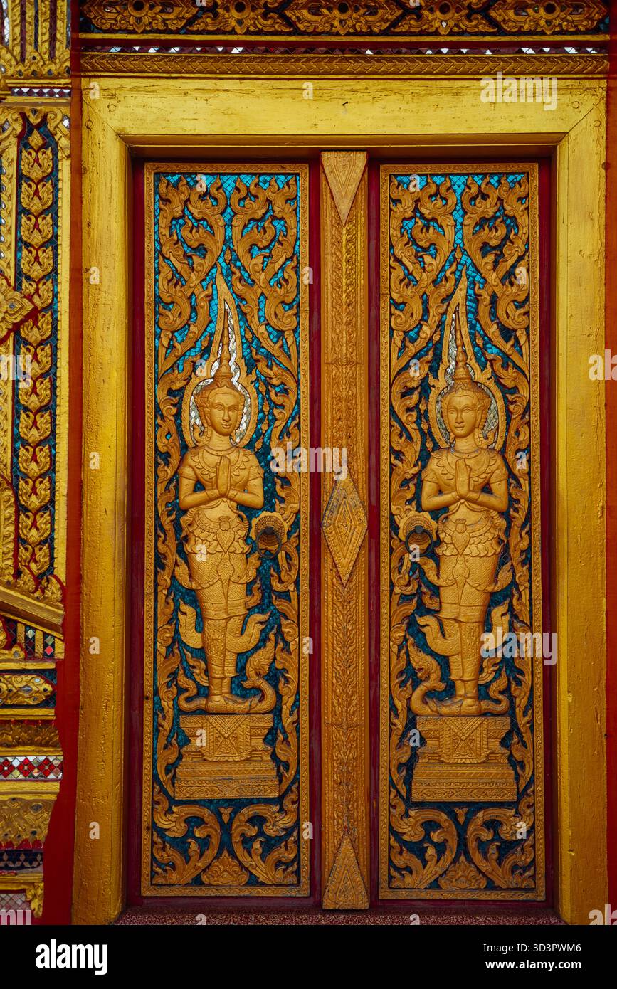 Kunstvoll geschnitzte hölzerne Tempeltür im Wat Chalong, Phuket, Thailand Stockfoto