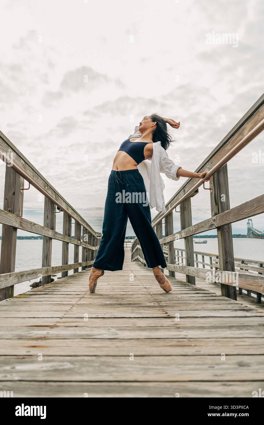Asiatische Tänzerin, die Ballett auf Holzsteg übt Stockfoto