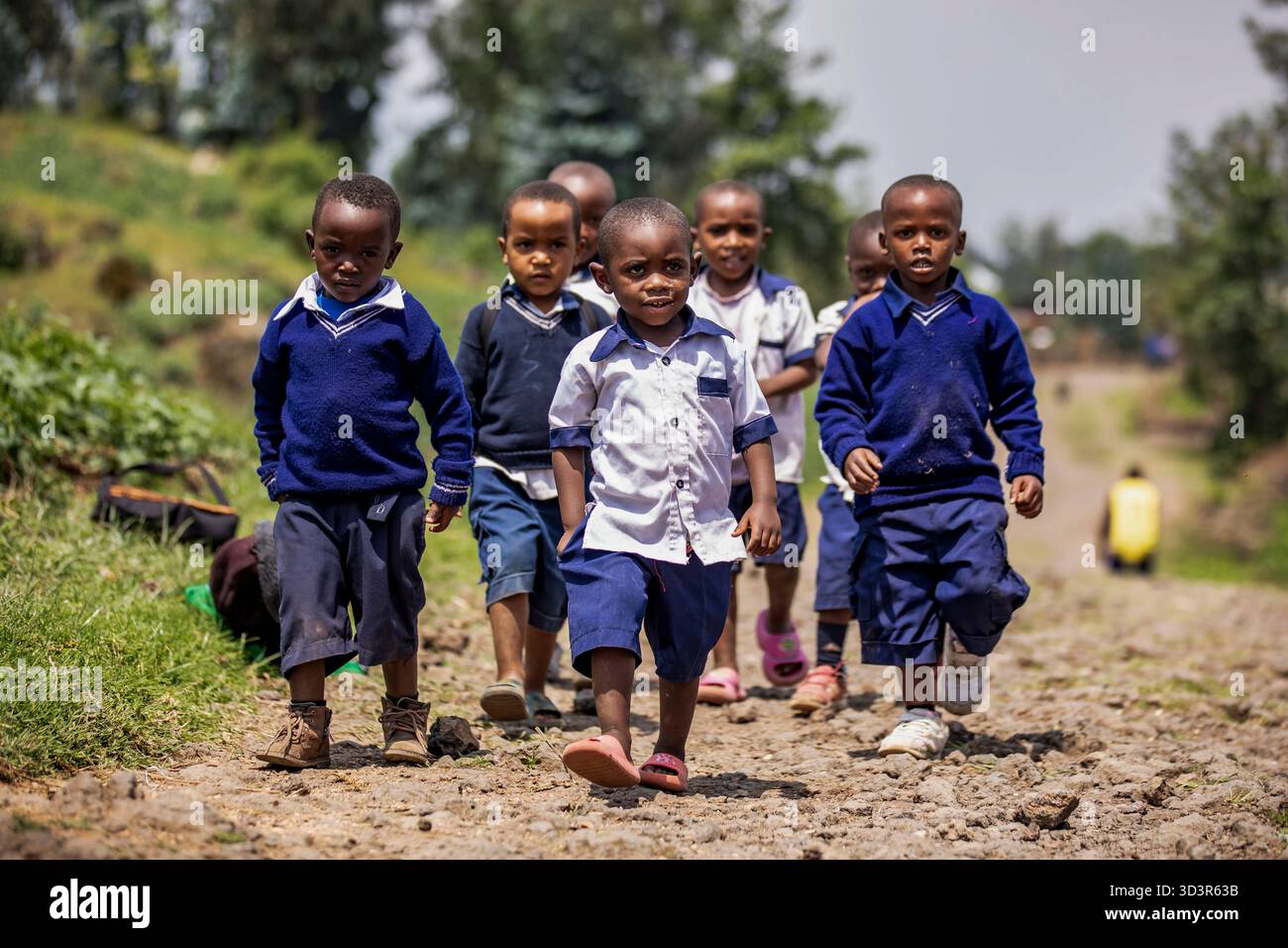 RUANDA, Kinder gehen von der Schule in Musanze, Ruanda, nach Hause. Viele von Familien mit niedrigem Einkommen wandern täglich mehrere Kilometer, um Zugang zu Bildung zu erhalten. Stockfoto