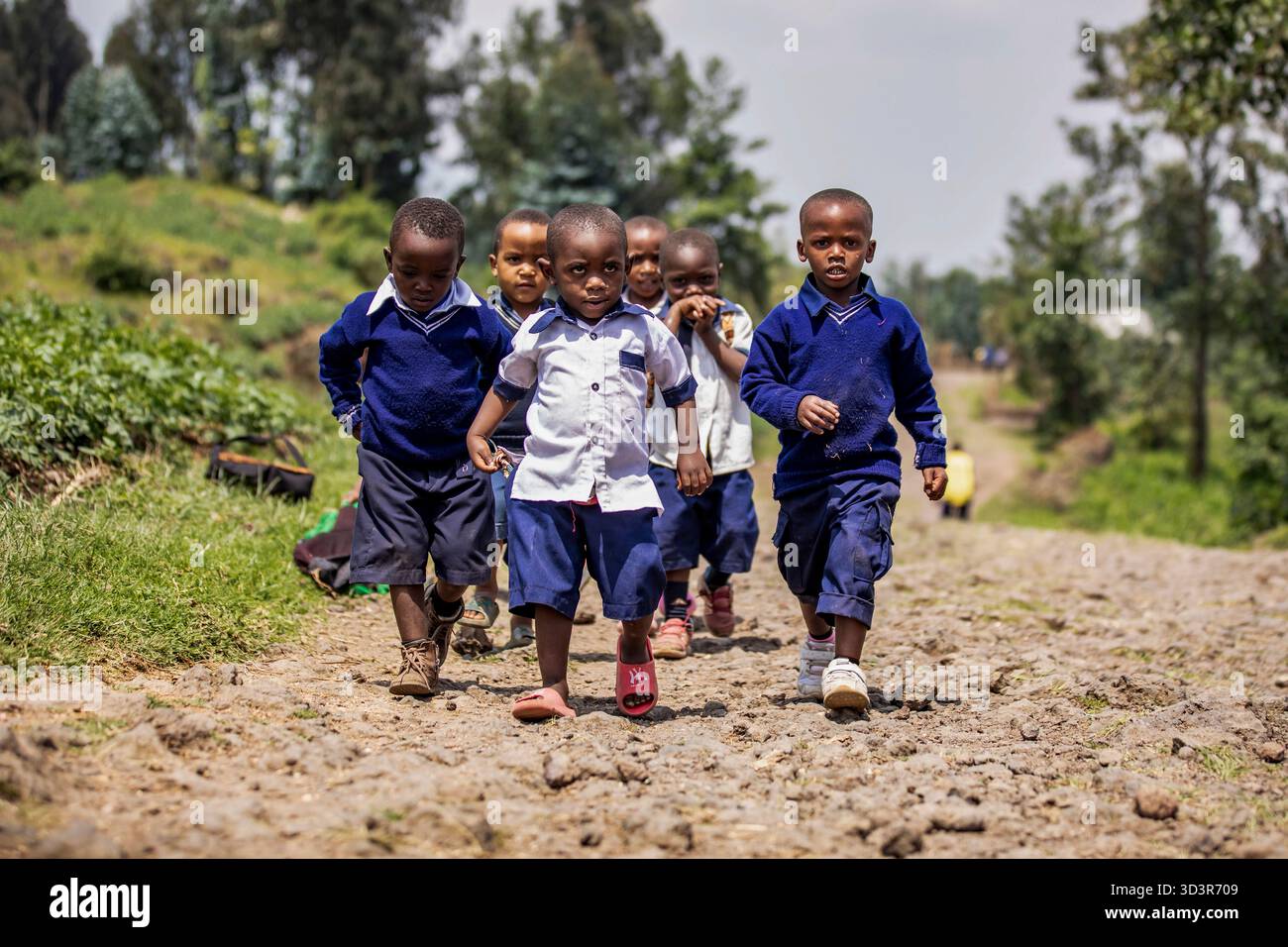 RUANDA, Kinder gehen von der Schule in Musanze, Ruanda, nach Hause. Viele von Familien mit niedrigem Einkommen wandern täglich mehrere Kilometer, um Zugang zu Bildung zu erhalten. Stockfoto