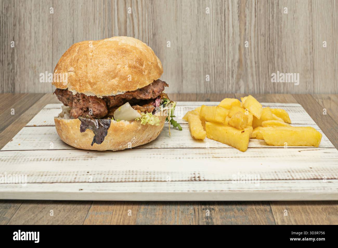 Rindfleisch-Burger mit Manchego-Käse, Manchego-Ratatouille und Olivenöl auf rustikalem Brot Stockfoto