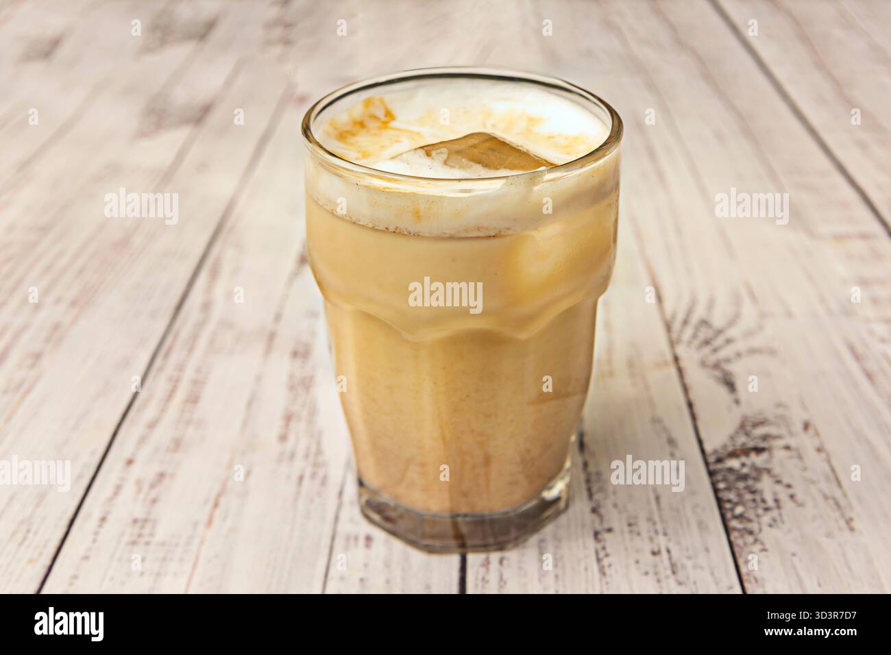 Kaltgefilterter Eiskaffee mit doppeltem Espresso, kaltgedämpfter Vollmilch und Latte Art darüber Stockfoto