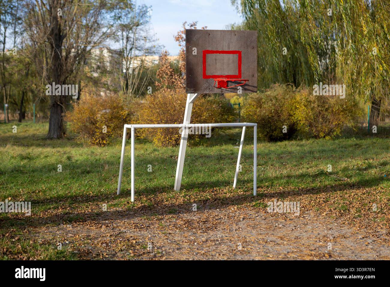 Ein Basketballkorb und Tore stehen auf einem offenen Sportplatz und symbolisieren Energie, Aktivität und urbanes Leben. Stockfoto