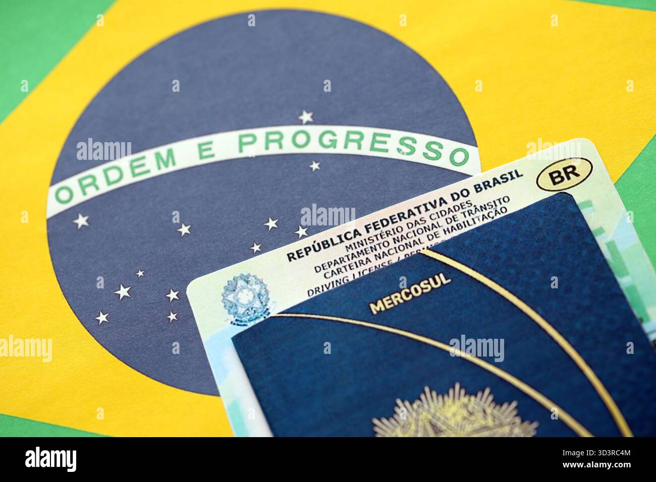 Brasilianischer Führerschein für ein Kraftfahrzeug mit Reisepass auf brasilianischer Flagge in Nahaufnahme Stockfoto