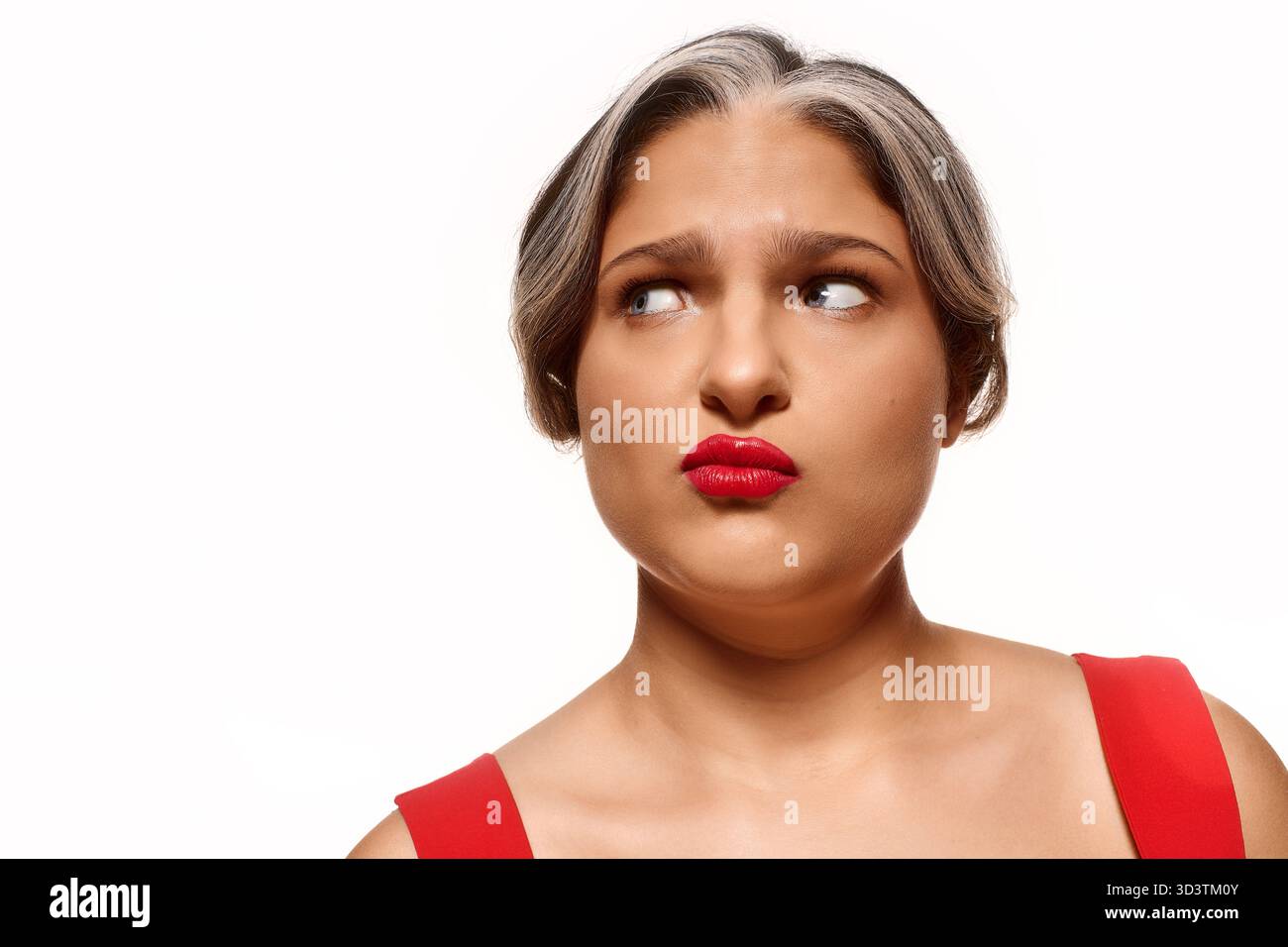 Diese Frau zeigt ihre einzigartige Schönheit mit einer weißen Stirnpartie und roten Lippen vor weißem Hintergrund. Stockfoto