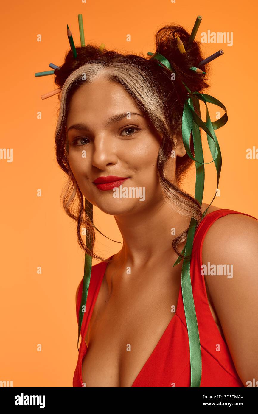 Eine junge Frau posiert selbstbewusst mit Bändern im Haar und unterstreicht ihre einzigartige Schönheit. Stockfoto