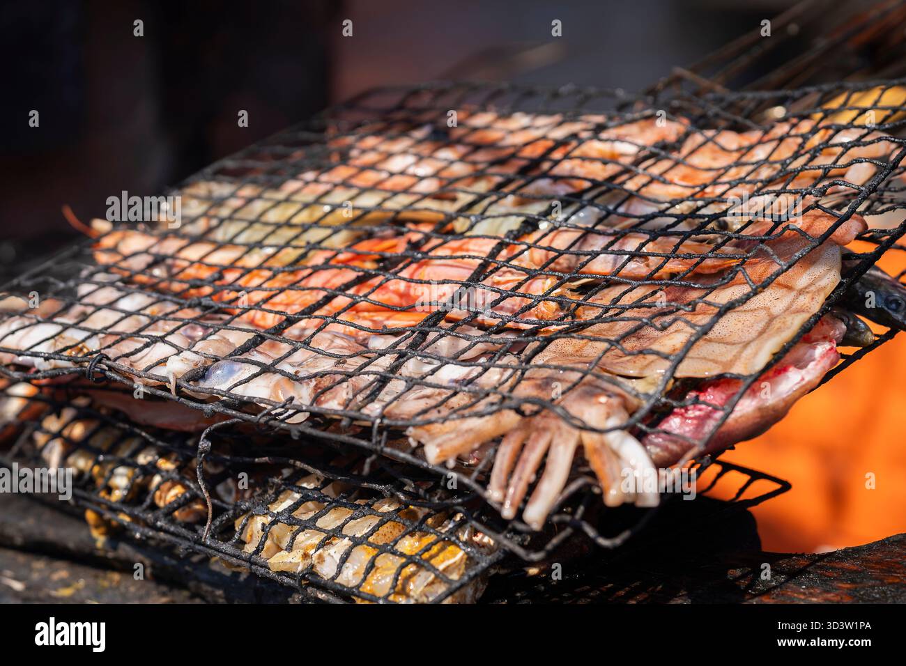 Lokale Meeresfrüchte auf einem Holzkohlegrill, Essaouira. Die Kunst, Fisch und Meeresfrüchte auf Holzkohle zu grillen. Straßengrill mit Meeresfrüchten in Essaouira. Stockfoto
