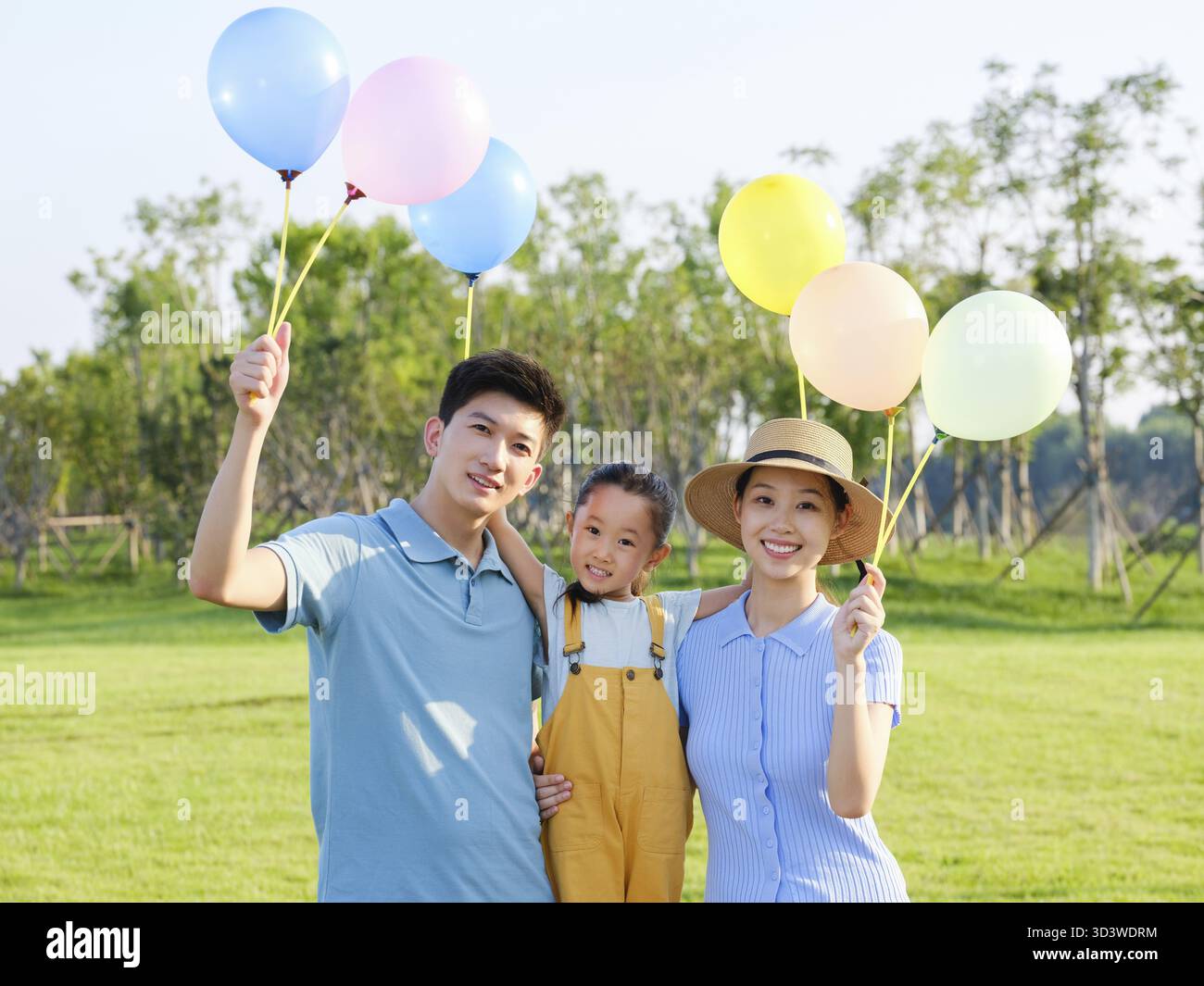 Glückliche Familie von drei im Park mit Blick auf die Kamera Stockfoto