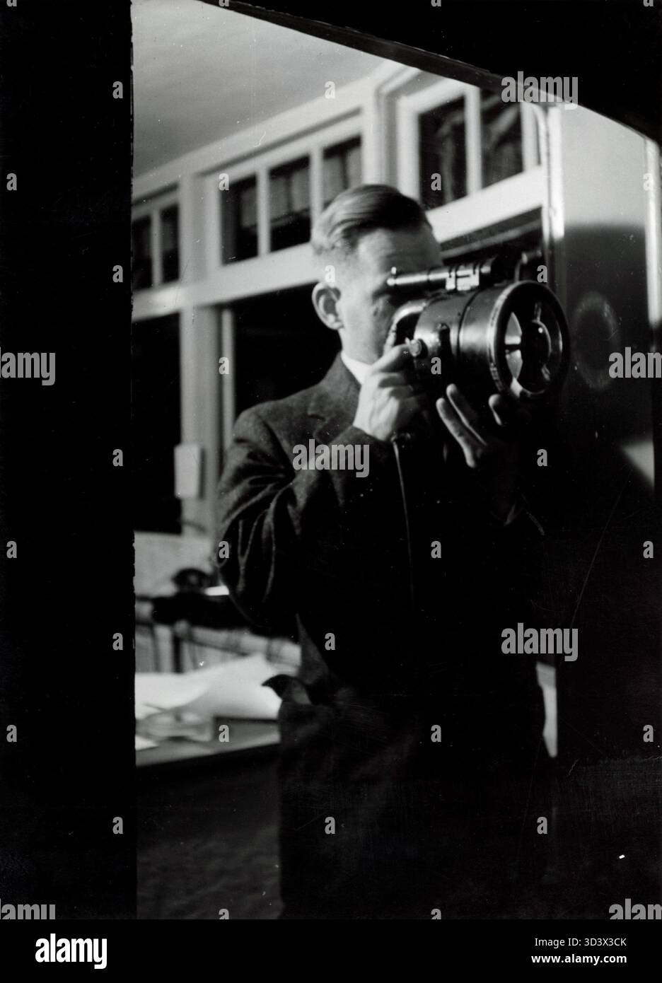 Vom Kontrollturm am Flughafen Schiphol aus im Jahr 1939 meldet ein Fluglotse ein Flugzeug mit einer Lampe zum Start. Dieses Foto zeigt frühe Signalmethoden, die in der Luftfahrt verwendet werden. Stockfoto