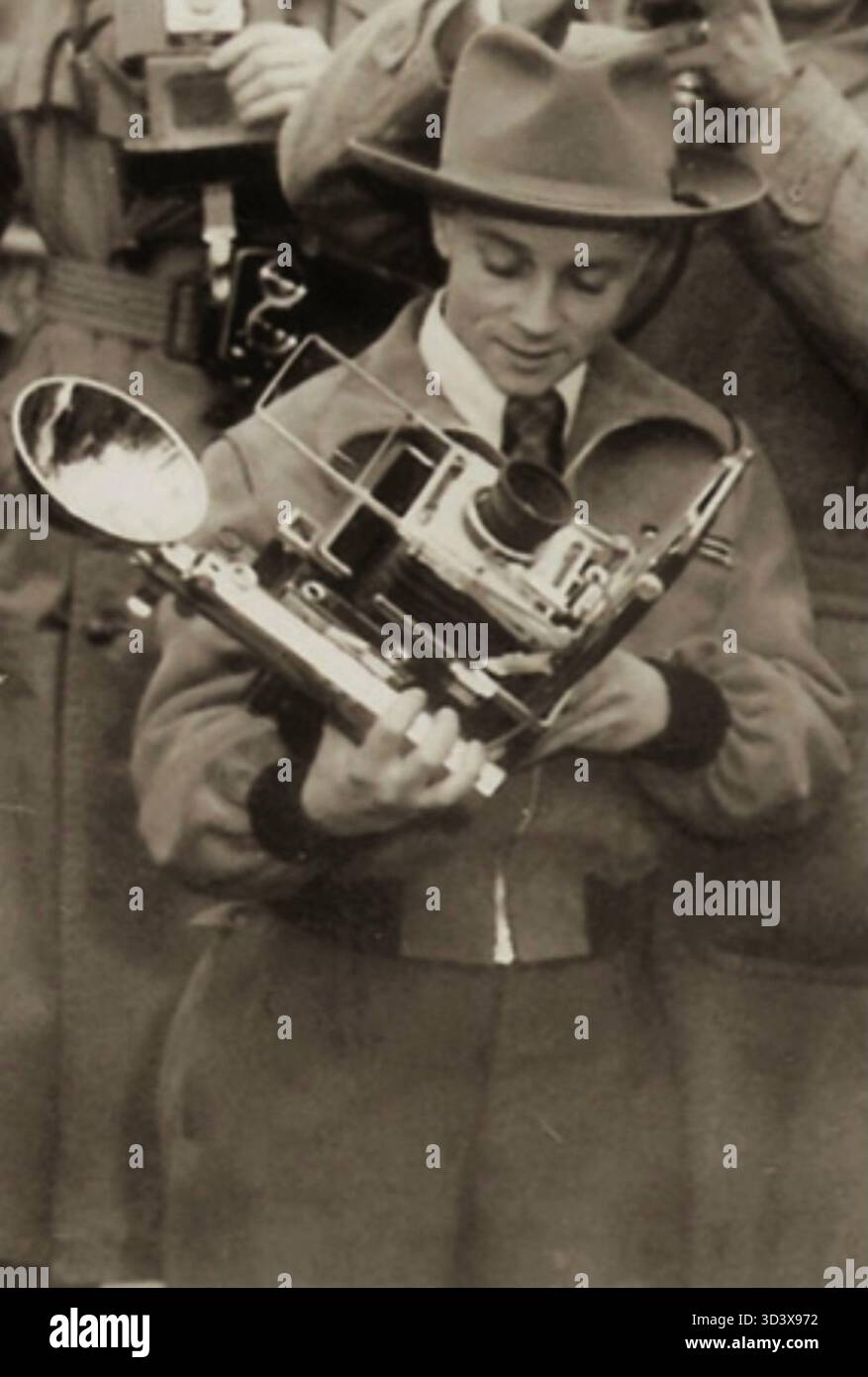 Anfang der 1950er Jahre überprüft der deutsche Pressefotograf Mickey Bohnacker seine Graflex Speed Graphic Kamera während eines Treffens mit General Lucius D. Clay in Frankfurt. Dieses Bild spiegelt die enge Verbindung zwischen Fotojournalismus und Militärgeschichte in der Zeit nach dem Zweiten Weltkrieg wider. Stockfoto