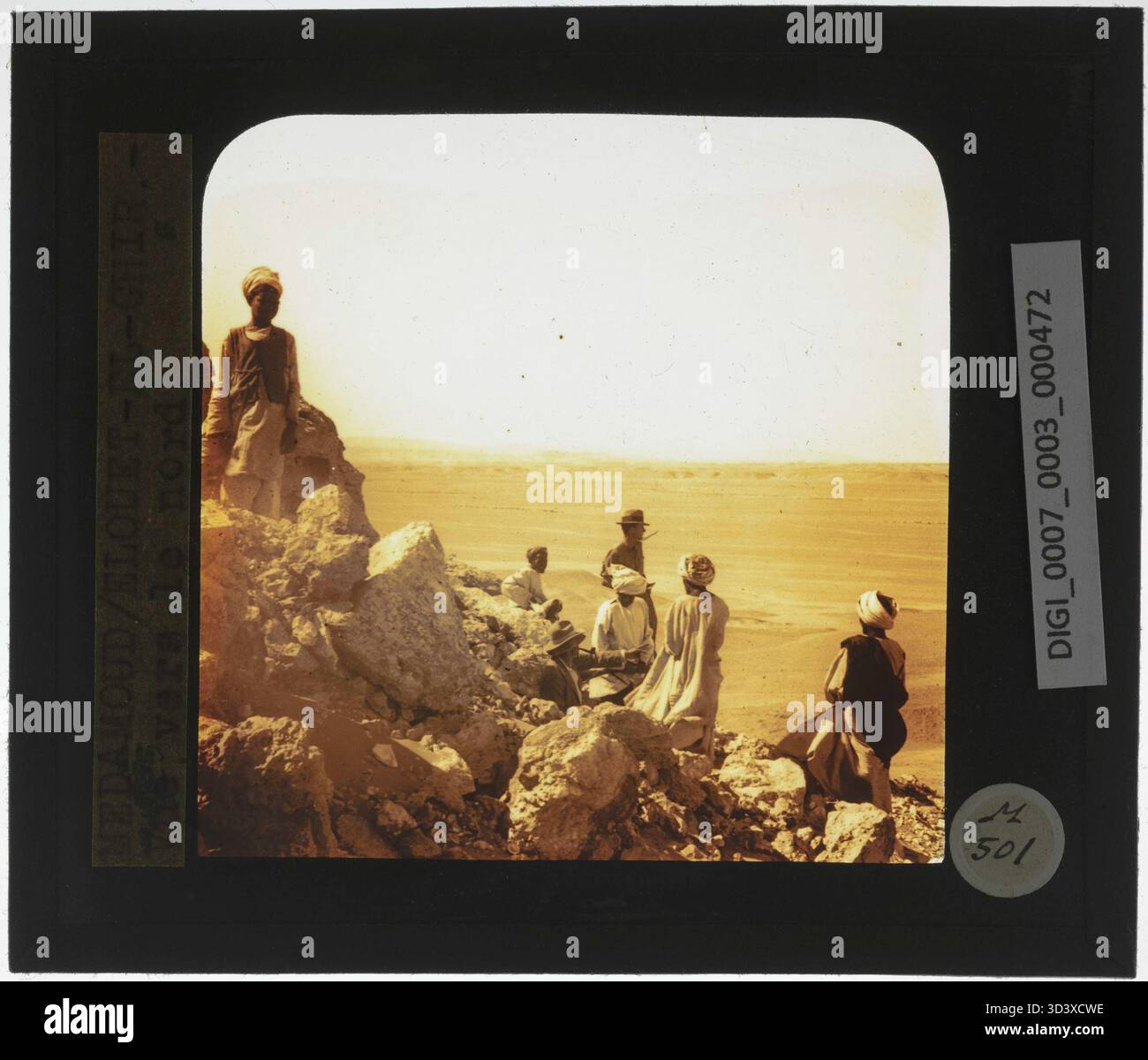 Ein Glasdiapositiv aus der Zeit um 1924-1932 zeigt Arbeiter und einen Archäologen auf einem Berg in Elouet El Ghir mit Blick nach Norden. Das Bild stellt die Mischung aus Arbeit und archäologischer Untersuchung in der Region dar. Stockfoto