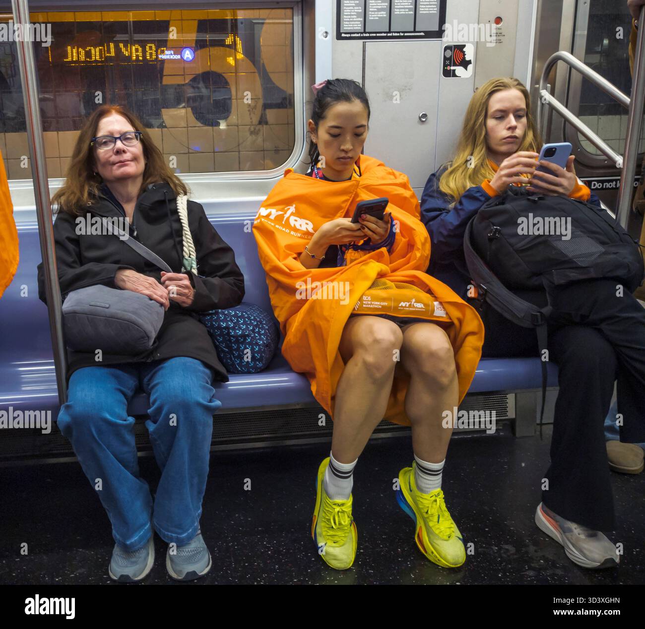 Marathonfinisator in der U-Bahn am Sonntag, den 2. November 2025, nach dem Lauf des TCS New York City Marathon. 50.000+ Teilnehmer liefen durch die fünf Bezirke. (© Richard B. Levine) Stockfoto