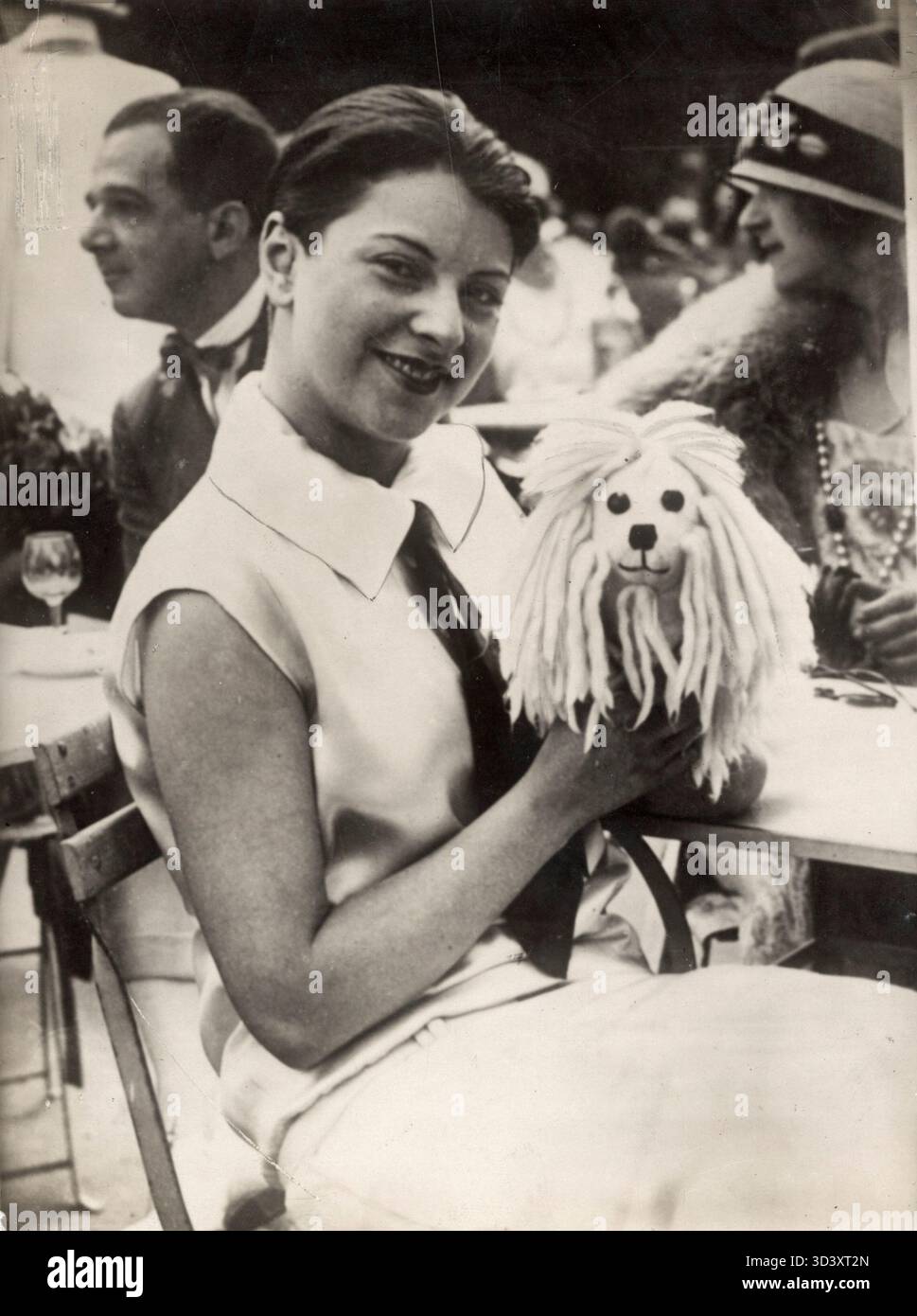 Eine Pariser Frau posiert 1924 auf einer Terrasse in Deauville, trägt ein Kleid mit Krawatte und trägt eine kurze, jungenhafte Frisur, die als „Jongenskop“ bekannt ist. Stockfoto