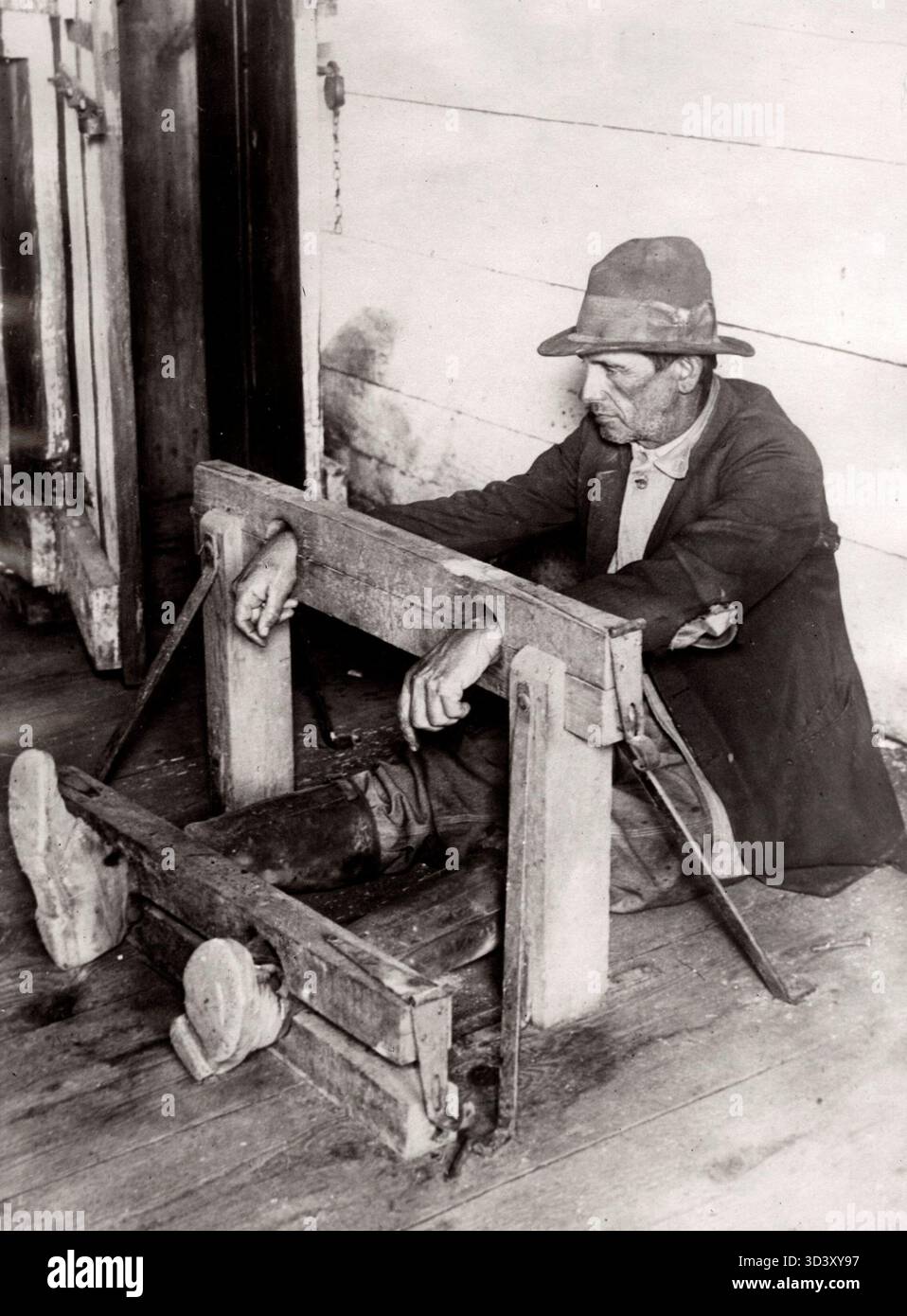 Im Jahr 1932 wird ein Mann in Atlanta, USA, als eine Form der körperlichen Bestrafung für eine Straftat an den Pranger gebunden. Das Bild zeigt diese harte historische Praxis. Stockfoto