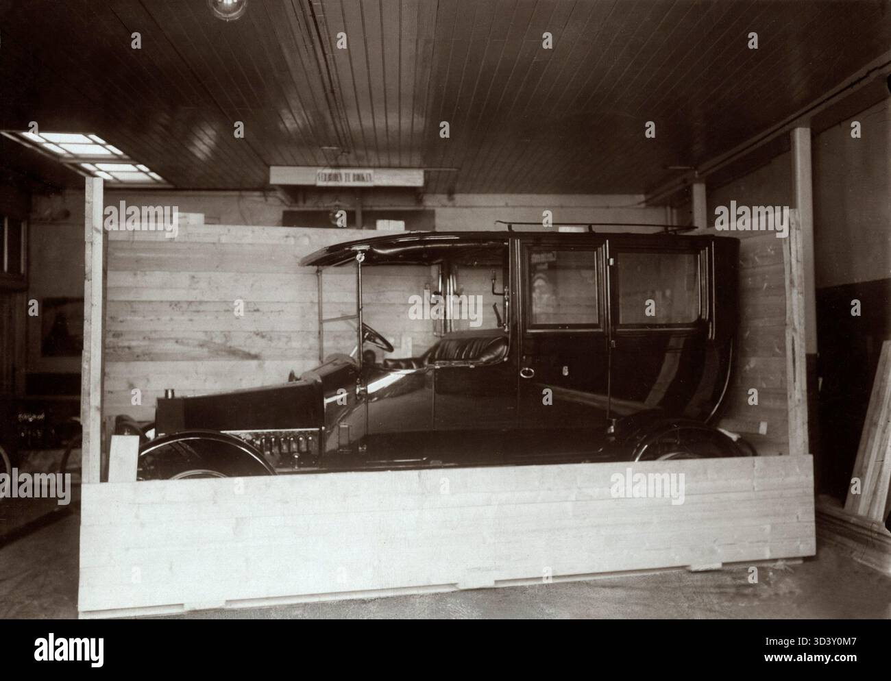 1914 erhielt Kardinal Willem Marinus van Rossum ein niederländisches Simplex-Auto als Geschenk. Der von Wilhelm Maybach entworfene und in Amsterdam gebaute Wagen hatte eine Höchstgeschwindigkeit von 80 km/h. Das Foto zeigt das Fahrzeug in Holzverpackung in der Simplex-Fabrik auf dem Overtoom, mit Kutsche von Kimman in Haarlem. Stockfoto