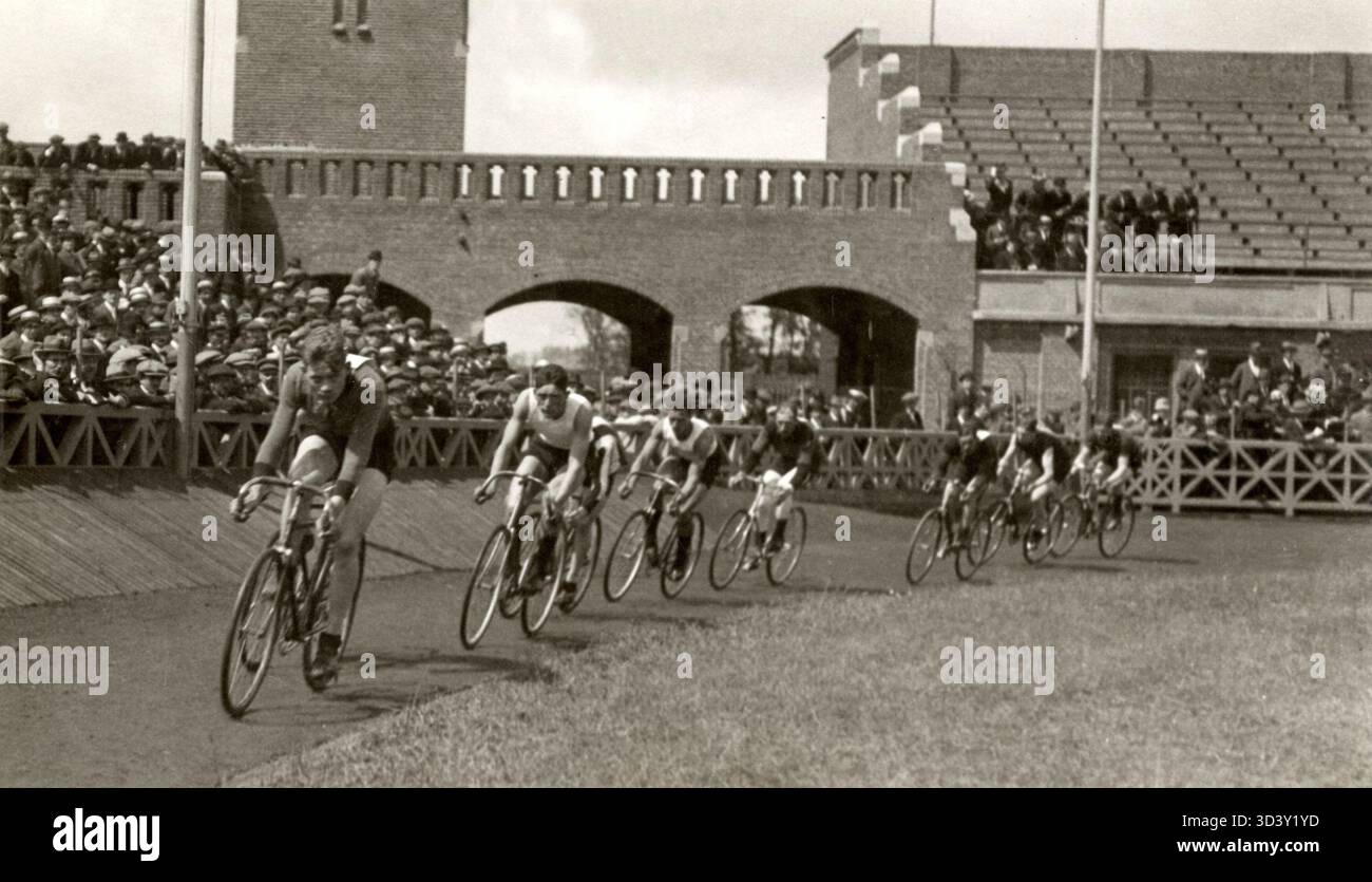 Die ersten Radrennen fanden 1918 im neu errichteten Stadion in Amsterdam, Niederlande, statt. Radfahrer können auf der Strecke Runden fahren sehen. Stockfoto