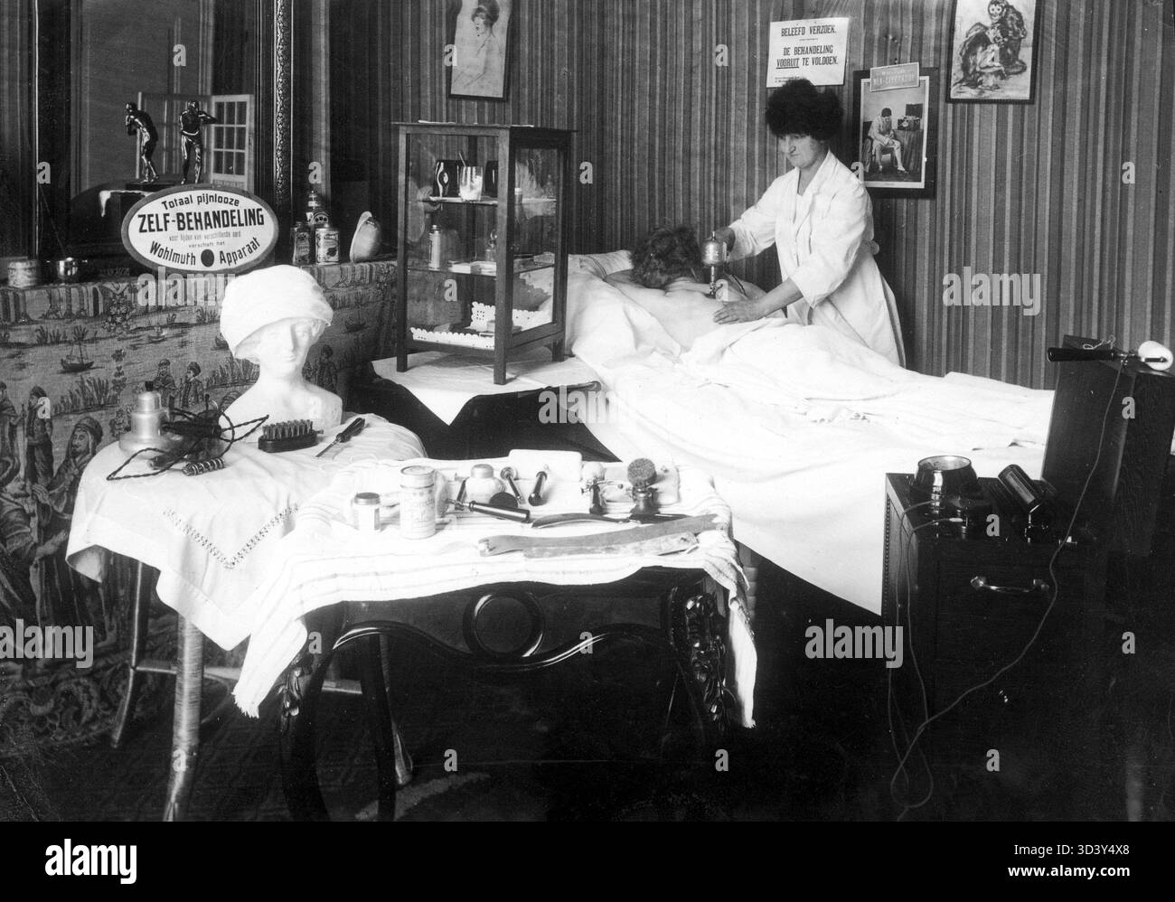 Dieses Foto aus dem Jahr 1926 zeigt eine Frau, die ein Massagegerät an einer anderen Frau in einem schwedischen Badehaus und Massagezentrum in den Haag, Niederlande, verwendet. Das Bild zeigt frühe Wellness-Praktiken des frühen 20. Jahrhunderts. Stockfoto