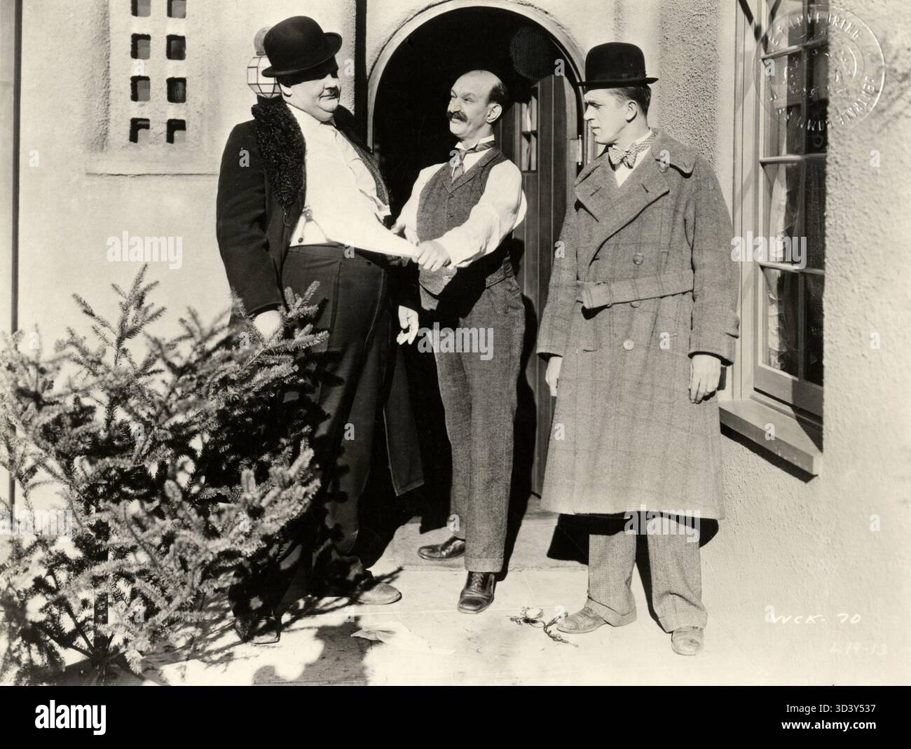 In dieser Szene aus dem Film „Big Business“ aus dem Jahr 1930 versuchen Stan Laurel und Oliver Hardy, James Finlayson einen Weihnachtsbaum zu verkaufen, der schließlich Ollies Hemd zerreißt. Der komödiantische Moment ist ein klassisches Beispiel für ihren Slapstick-Humor. Stockfoto