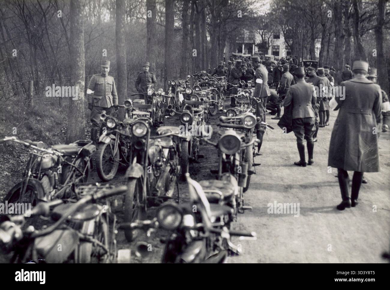 Eine Reihe von Motorrädern niederländischer Soldaten vor einem Rennen um 1930. Die Soldaten stehen bereit für die Veranstaltung und zeigen ihre Fahrzeuge und die Vorbereitungen auf den Wettbewerb. Stockfoto