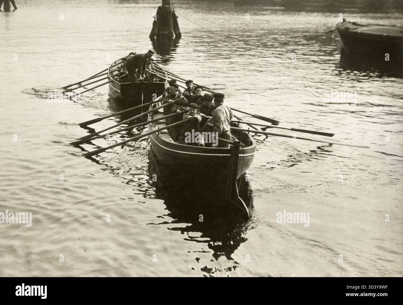Rekruten auf dem Ausbildungsschiff "Pollux" in Amsterdam üben das Rudern eines Rettungsbootes, 1918. Diese Übung ist Teil ihrer grundlegenden Ausbildung in der Seefahrt. Stockfoto