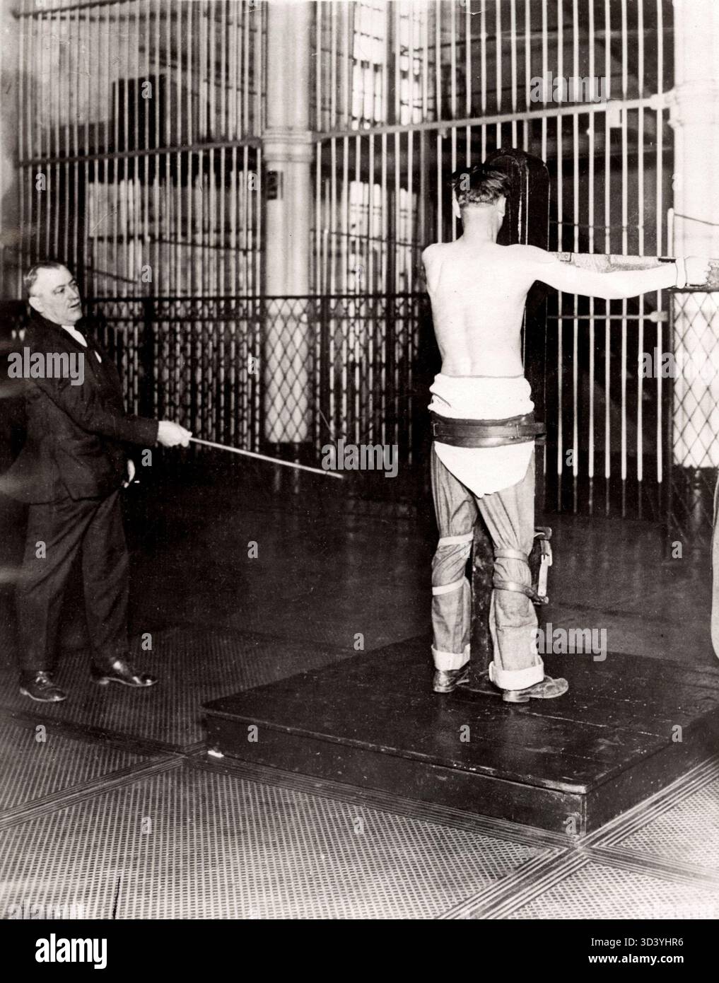 1938 wird ein Mann in Baltimore öffentlich ausgepeitscht, weil er seine Frau geschlagen hat. Das Bild spiegelt die historische Anwendung der Körperstrafe als gesetzliche Strafe wider. Stockfoto