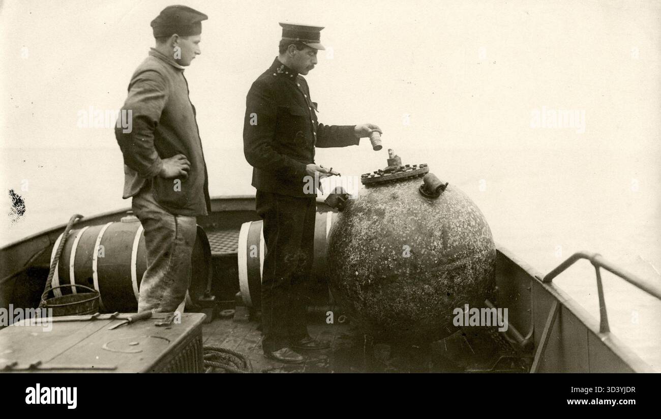 Lt. Th. Mollinger, Anführer des Torpedo-Korps aus Gorinchem, inspiziert eine abgebaute englische Landmine und entfernt ihren Zünder, um sicherzustellen, dass sie sicher ist, 1918 in Oosterschelde. Stockfoto