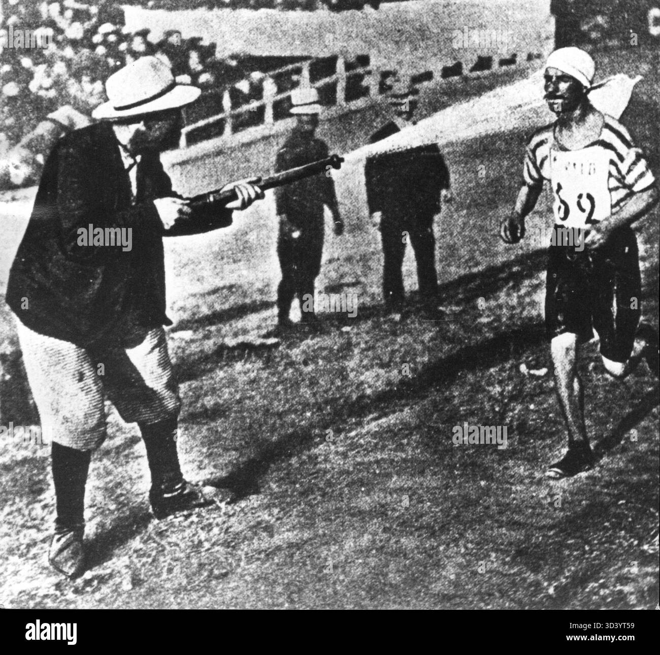 Während des Olympischen Marathons 1900 in Paris wurde ein Läufer mit Wasser aus einem Gartenschlauch besprüht, um sich während der Fortsetzung des Rennens abzukühlen. Stockfoto