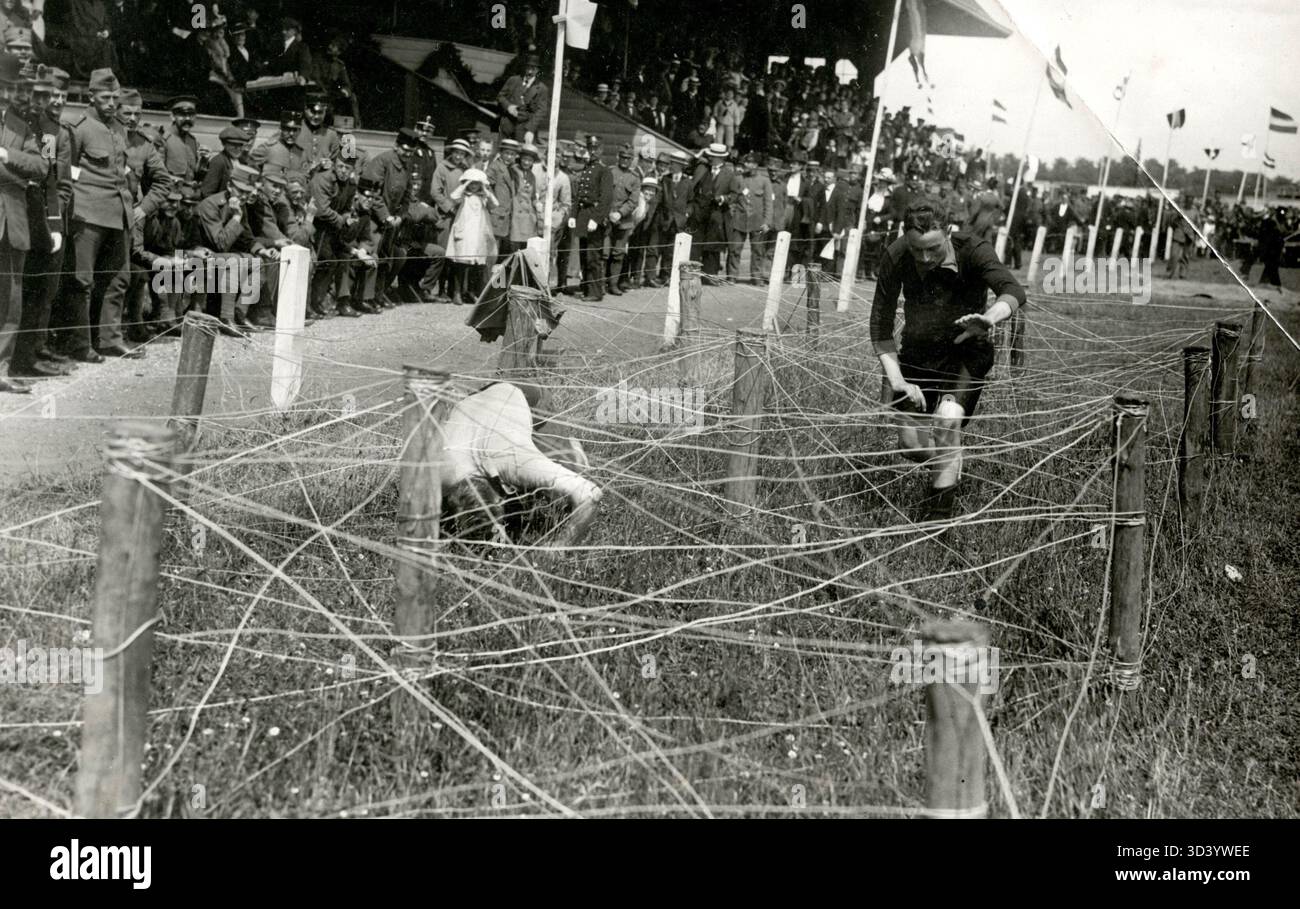 Niederländische Soldaten kämpfen 1916 bei einem Militärsportereignis in den Niederlanden durch ein Netz straffer Kabel. Stockfoto