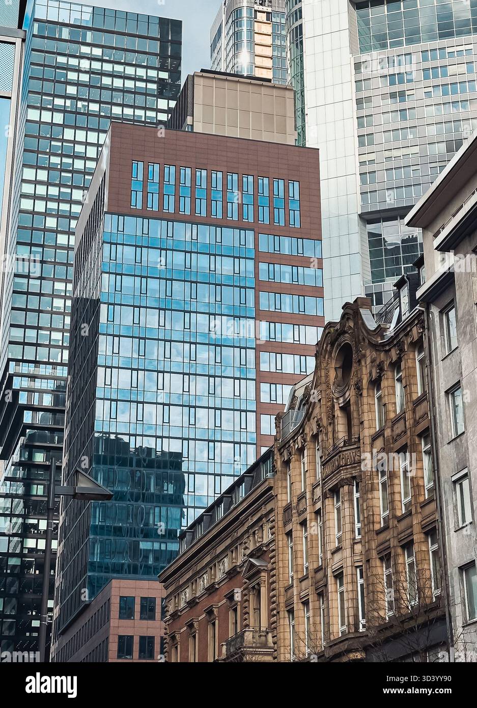 Urbanes Stadtbild mit modernen Wolkenkratzern und historischer Architektur, die kontrastierende Stile und Texturen in einer lebendigen Umgebung zeigt Stockfoto