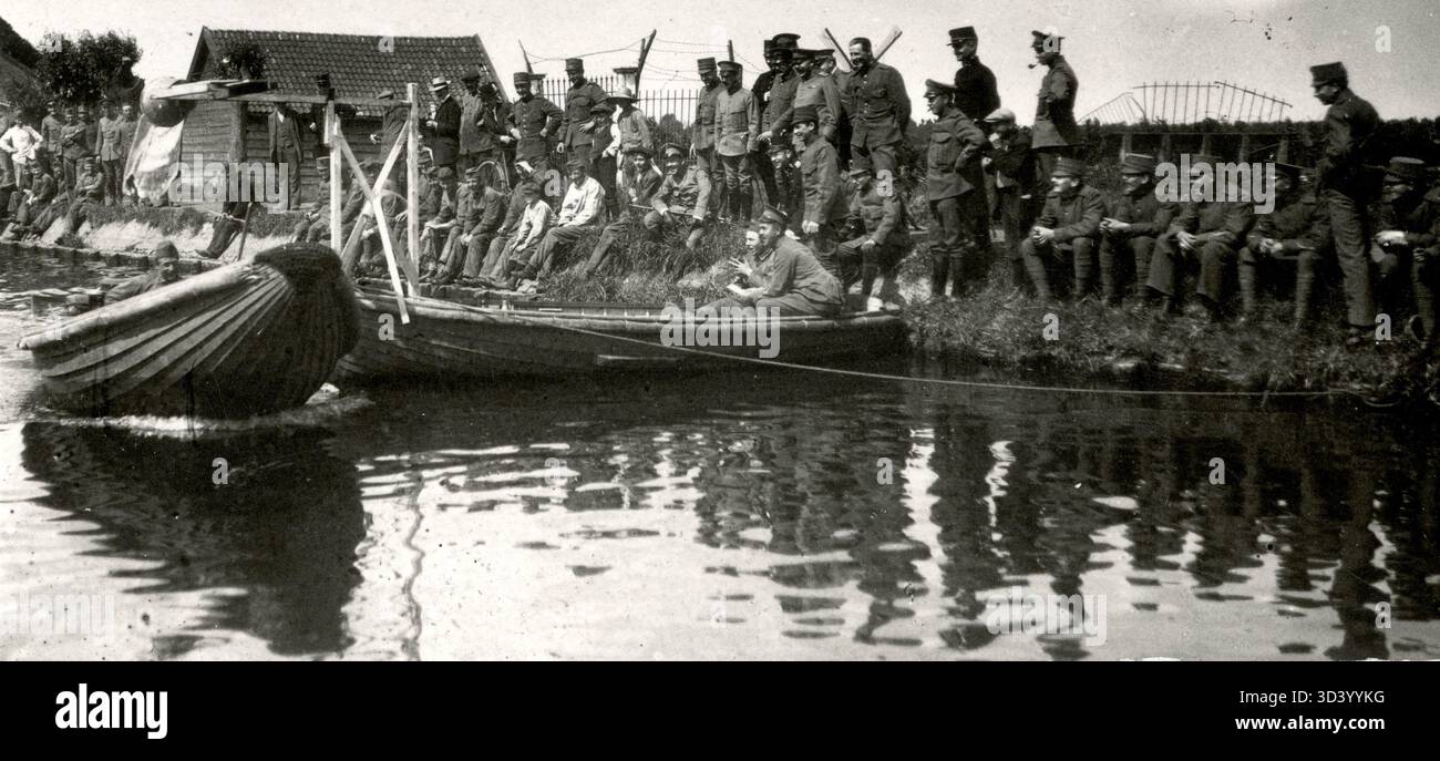 Niederländische Soldaten beobachten ein Boot, das an der Küste vorbeifährt, während einer Militärfeier in den Niederlanden, 1917. Stockfoto