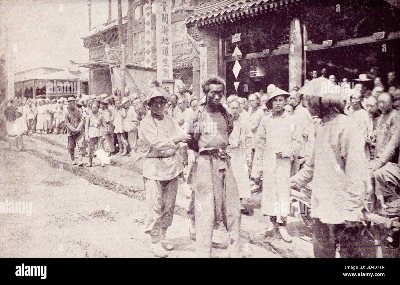 Dieses Foto von 1905-1906 aus Peking, China, zeigt eine öffentliche Hinrichtung von neun verurteilten Kriminellen. Die Szene zeigt, wie die Verurteilten von Wärtern zum Hinrichtungsort begleitet werden, wo die Todesstrafe vollstreckt wird. Stockfoto