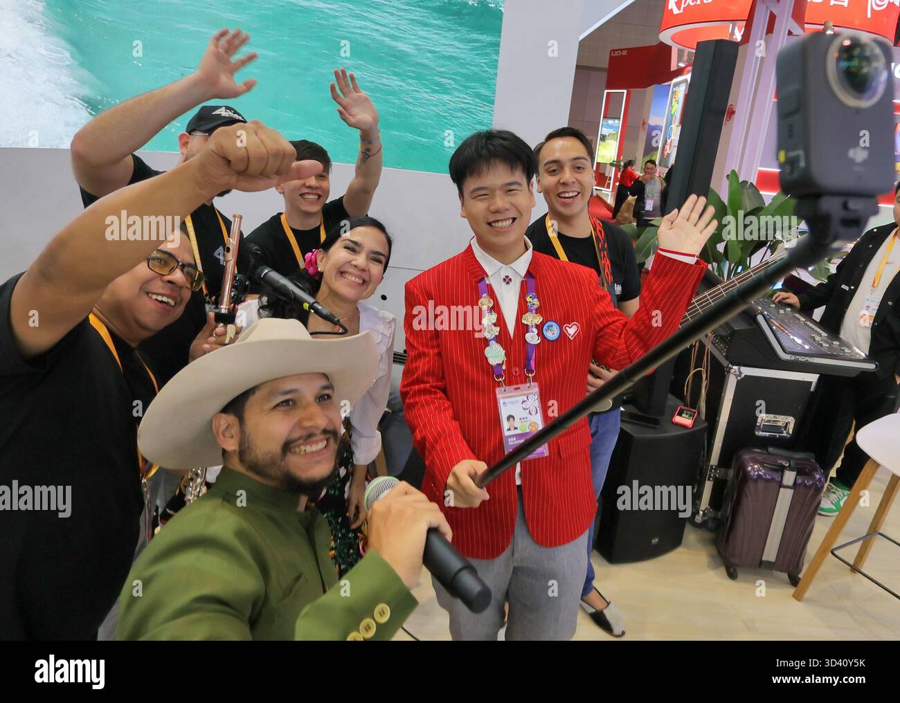 SHANGHAI, CHINA - 7. NOVEMBER 2025 - Mitglieder einer venezolanischen Band machten am 7. November 2025 ein Foto mit einem chinesischen Freiwilligen beim 8. CIIE in Shanghai, China. Stockfoto
