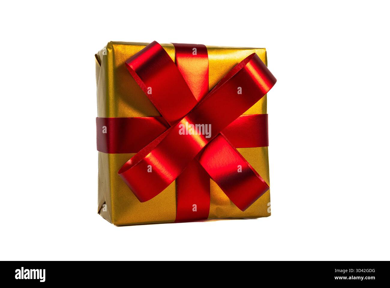 Hochwertiges goldenes Geschenk mit leuchtend rotem Band und Schleife, ideal für Weihnachtsaktionen, Luxusgeschenke oder Weihnachtsdekorationen. Stockfoto