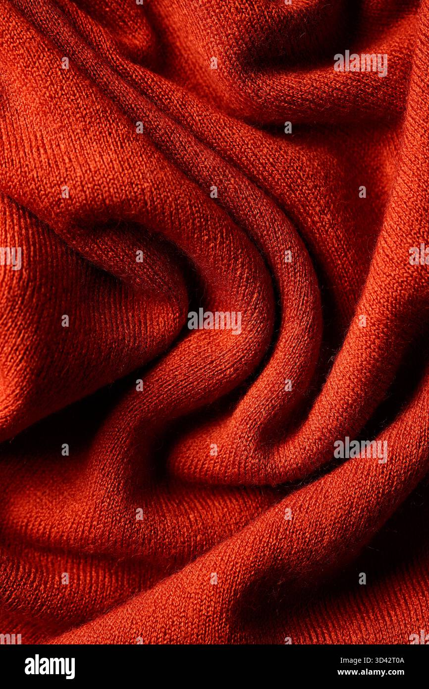 Strickware aus roter Wolle mit weichen Falten und detaillierter Textilstruktur. Kuscheliger, warmer Textilinhalt Stockfoto