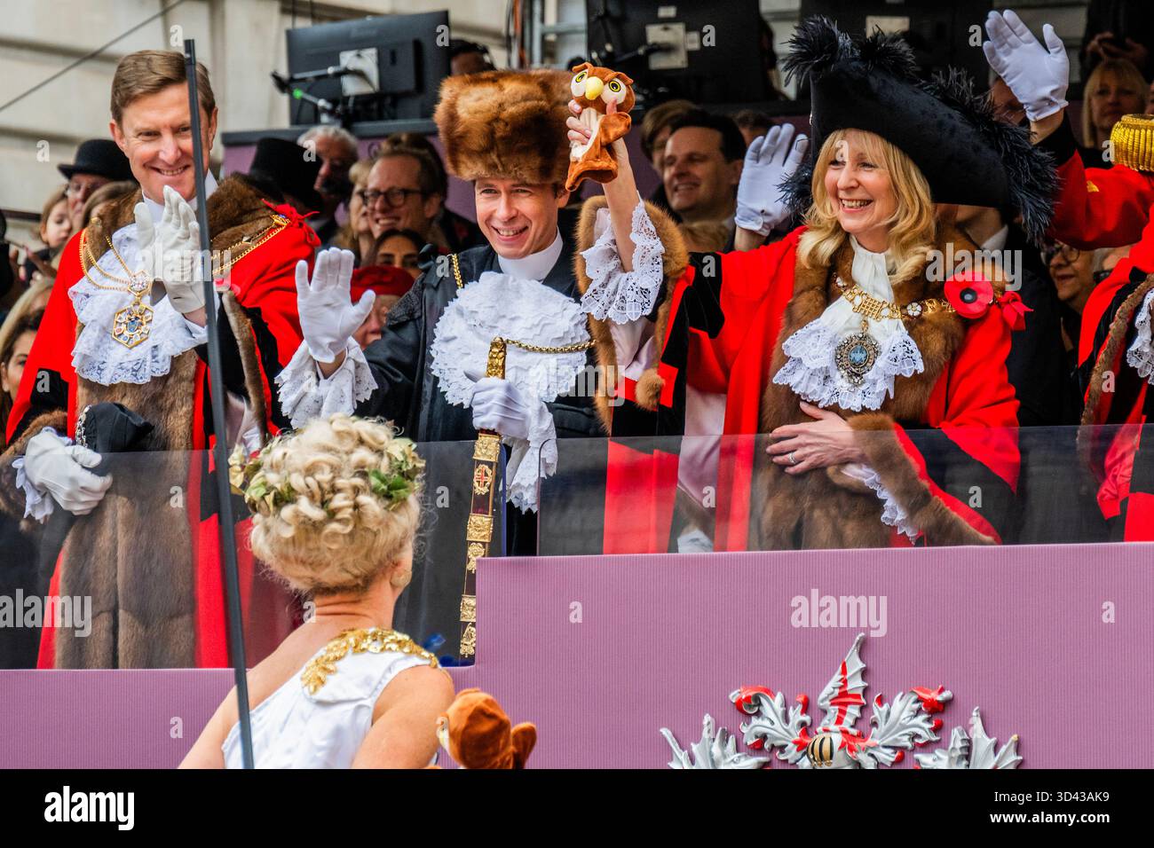 London, Großbritannien. November 2025. Eine Dame auf Stelzen aus der intitute of Couriers übergibt dem Bürgermeister die Handpuppe der Knowledge Eulen – die Lord Mayor’s Show 2025 stellt die 697. Lord Mayor of London, Dame Susan Langley DBE (im Bild), die zuvor aus der Aldgate-Gemeinde stammt, vor. Sie ist die dritte Frau, die das Amt seit über 800 Jahren innehatte, und die erste Frau, die den Titel „Lady Mayor of London“ erhielt. Die Show geht auf das frühe 13. Jahrhundert zurück, als König John gewährte, dass die City of London einen eigenen Bürgermeister ernennen könne, dass sie aber flussaufwärts nach Westminster kommen und der Krone Loyalität schwören müssten. Gutschrift: G Stockfoto