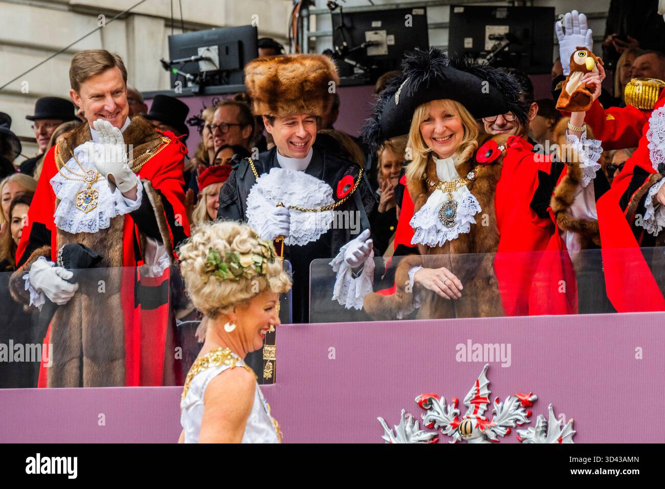London, Großbritannien. November 2025. Eine Dame auf Stelzen aus der intitute of Couriers übergibt dem Bürgermeister die Handpuppe der Knowledge Eulen – die Lord Mayor’s Show 2025 stellt die 697. Lord Mayor of London, Dame Susan Langley DBE (im Bild), die zuvor aus der Aldgate-Gemeinde stammt, vor. Sie ist die dritte Frau, die das Amt seit über 800 Jahren innehatte, und die erste Frau, die den Titel „Lady Mayor of London“ erhielt. Die Show geht auf das frühe 13. Jahrhundert zurück, als König John gewährte, dass die City of London einen eigenen Bürgermeister ernennen könne, dass sie aber flussaufwärts nach Westminster kommen und der Krone Loyalität schwören müssten. Gutschrift: G Stockfoto