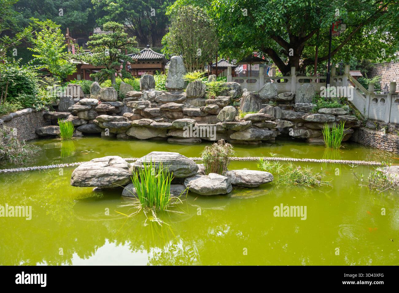 Klassischer chinesischer Garten mit Teich und Felsen. Landschaftsdesign-Stil, der wilde Aspekte der Natur wiedergibt. Stockfoto