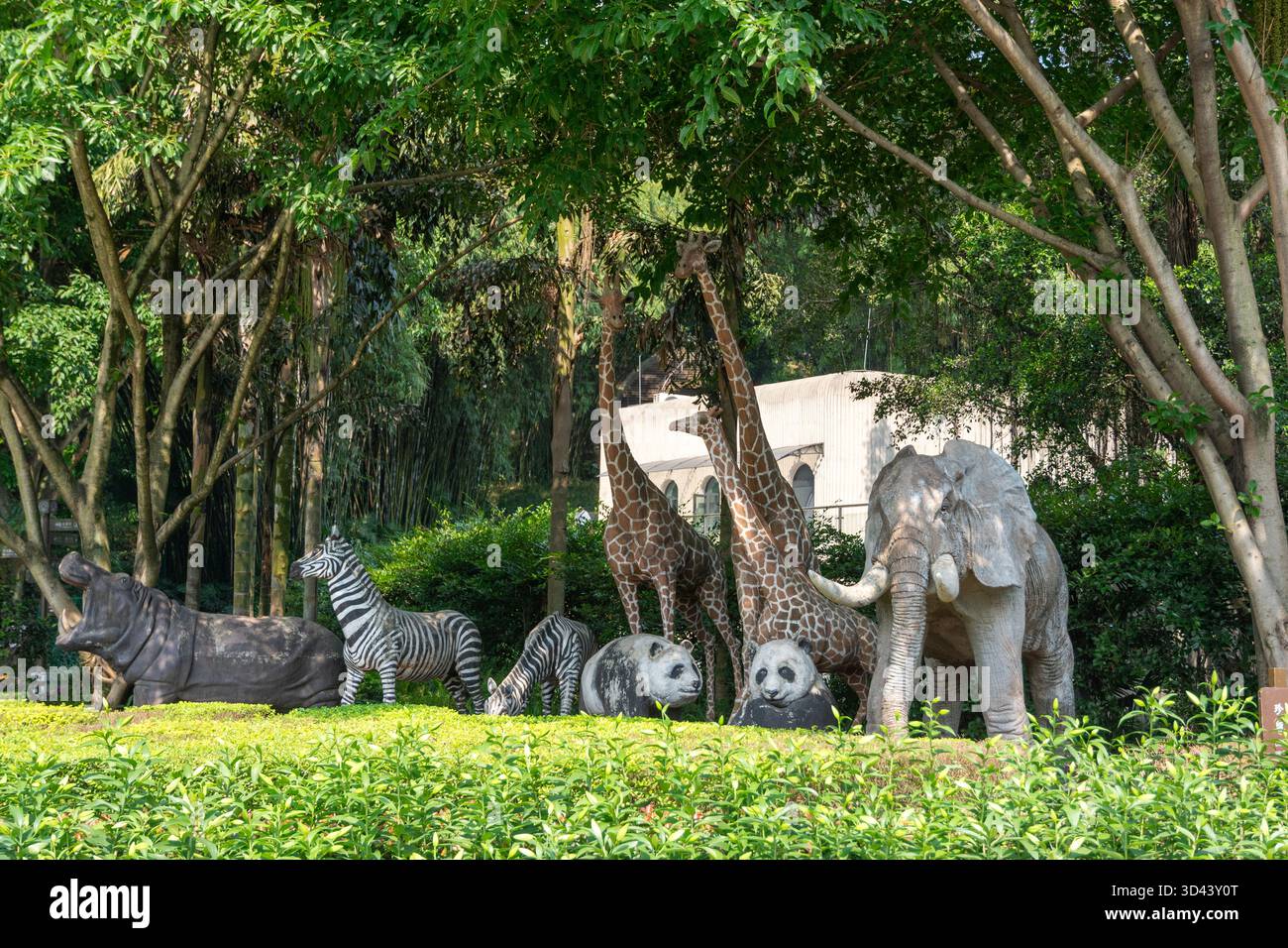 Sammlung von Tierskulpturen in einer üppigen, grünen Umgebung im Chongqing Zoo, China. Stockfoto
