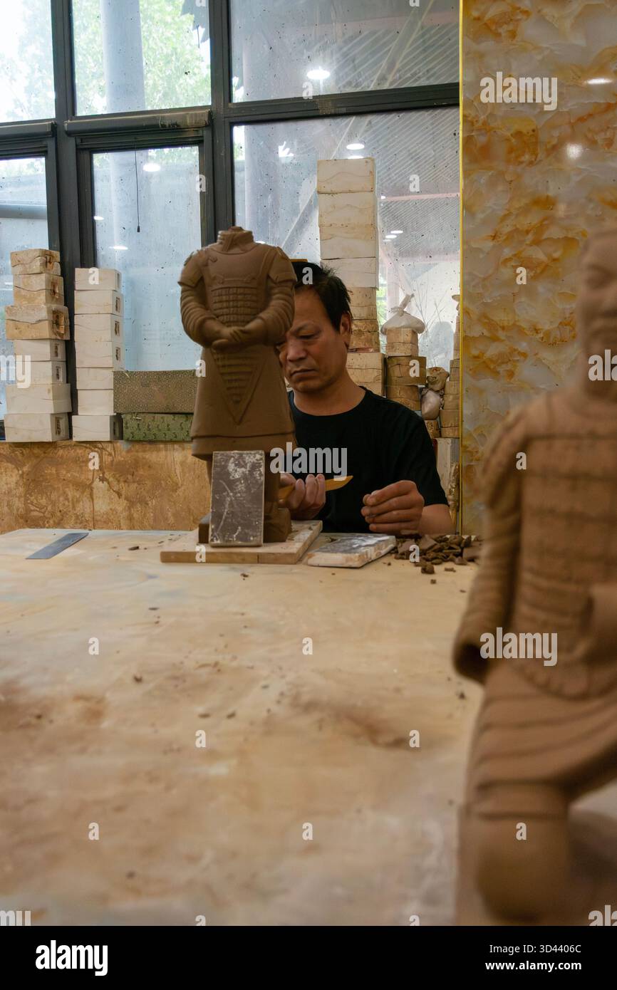 Arbeiter fertigen Nachbildungen von Soldaten der Terrakotta-Armee in einer Souvenirfabrik in Xi'an, China. Stockfoto
