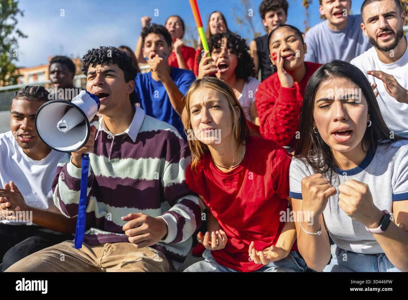 Verschiedene Gruppen junger Menschen versammelten sich zu einem Protest oder einer Kundgebung, drückten starke Emotionen und Unterstützung aus, ein Mann sprach leidenschaftlich zu einem Megaphon Stockfoto