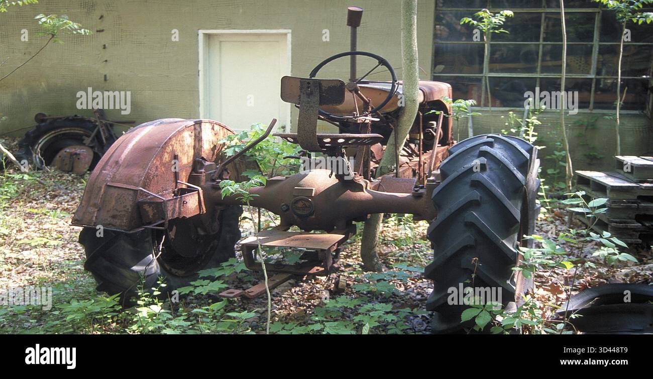 Verrosteter Traktor auf einem Autofriedhof in einem Wald, Marksboro, New Jersey, USA Stockfoto