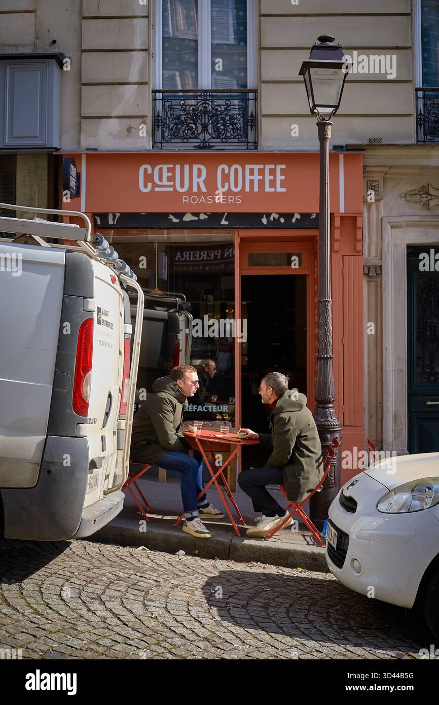 Freunde genießen an einem sonnigen Tag Kaffee in einem Straßencafé in Montmartre, Paris, Frankreich Stockfoto