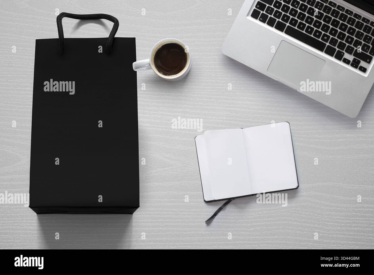 Online-Shopping und Entspannung flach lag mit einer Einkaufstasche, Kaffeetasse, einem Computer und einem Notebook Stockfoto