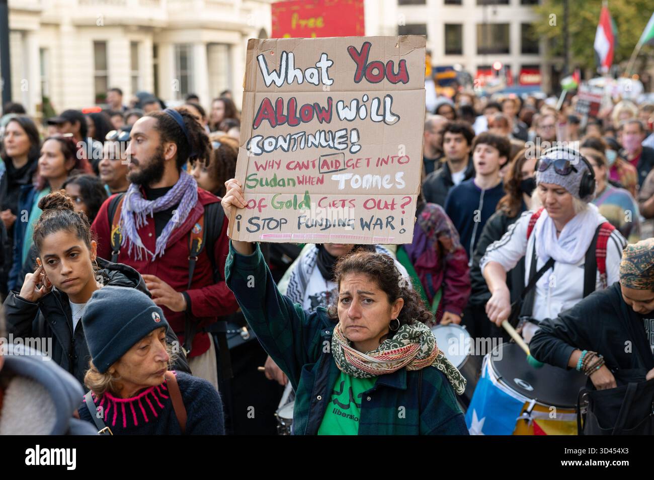 London, Großbritannien. November 2025. Eine Frau hält ein Plakat, während sie während der Kundgebung marschiert. Demonstranten marschierten in London, um Solidarität mit dem sudanesischen Volk zu zeigen und für ein Ende der britischen Waffenverkäufe an die VAE zu plädieren, die laut Aktivisten Gräueltaten der RSF-Miliz im ganzen Land ermöglichen. Quelle: SOPA Images Limited/Alamy Live News Stockfoto